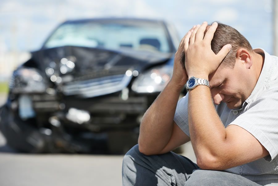 A motorist in despair after crashing his car