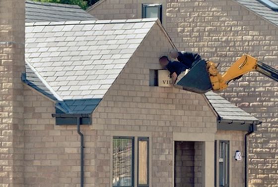 A digger being used to lift a worker