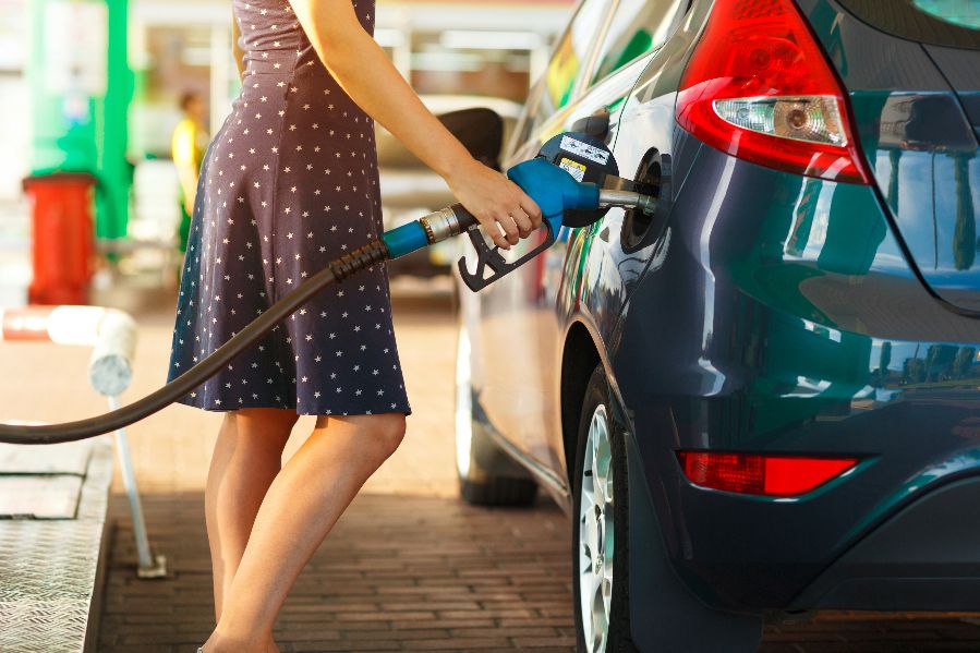 A woman filling her car's tank with fuel