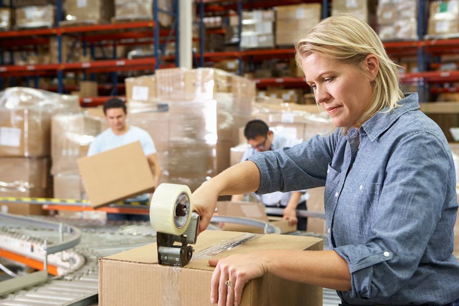 A female worker sealing a carton