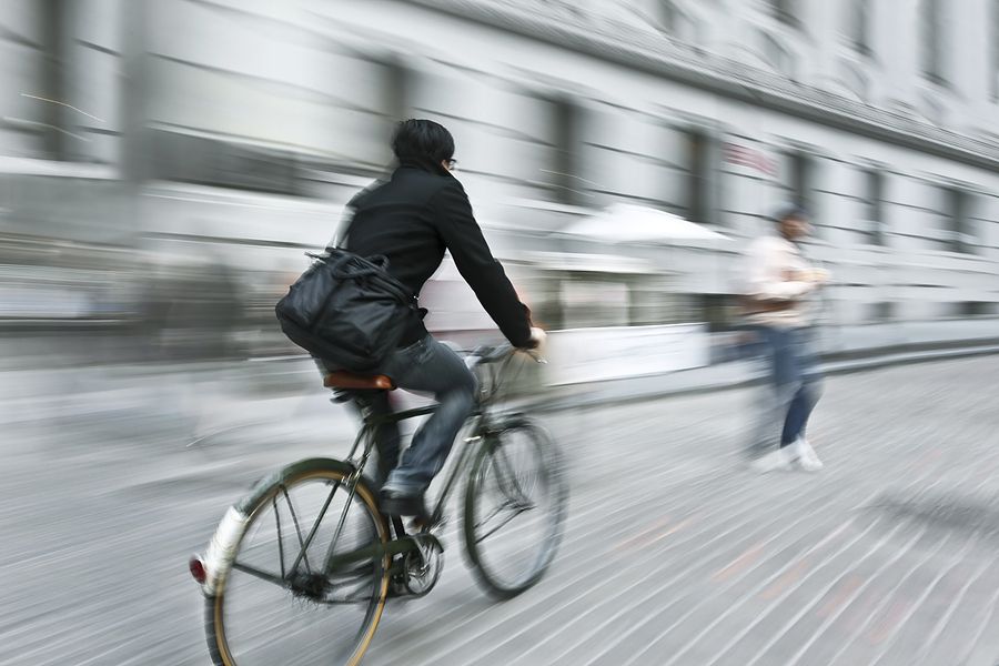 A bicycle heading towards a pedestrian who has stepped into the street without looking