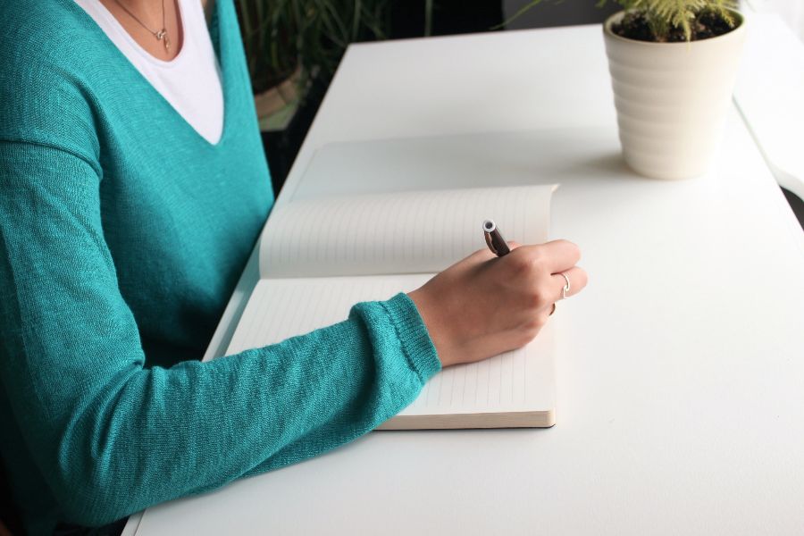 A woman sitting at a table signing a document